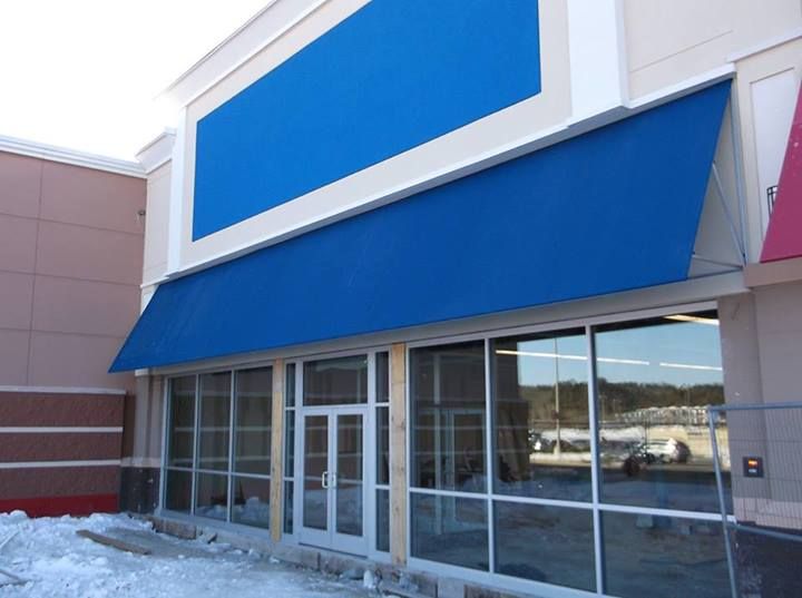 A store front with a blue awning over the door