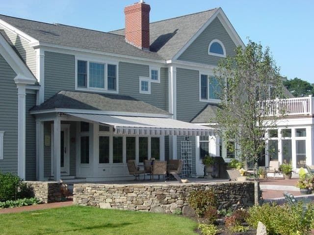 A large house with a white awning on the porch