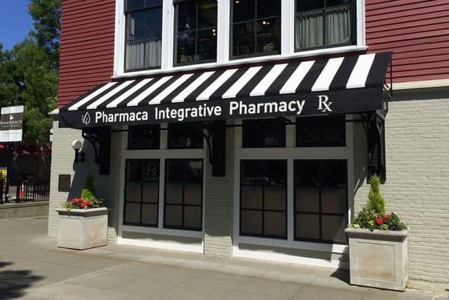 A pharmacy with a black and white awning over it