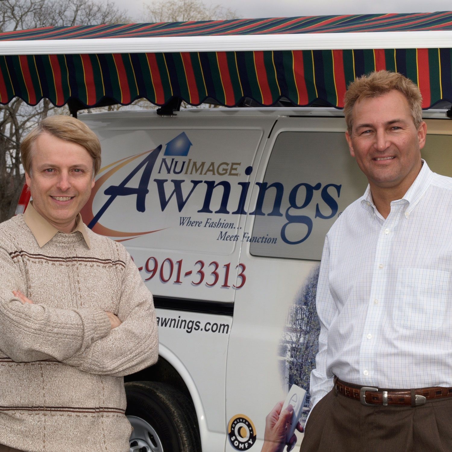 Two men standing in front of a nuimage awnings van