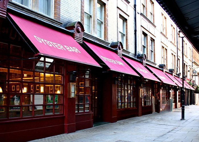 A building with a red awning that says oyster bar