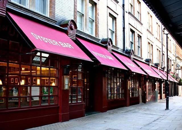 A building with a red awning that says oyster bar
