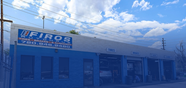A blue and white automotive repair shop named Firos, featuring multiple service bays and a phone number on the facade | Firos Auto House 2