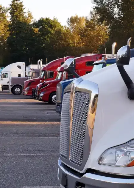 A person works on a large, disassembled V-shaped engine suspended from a stand in a garage.