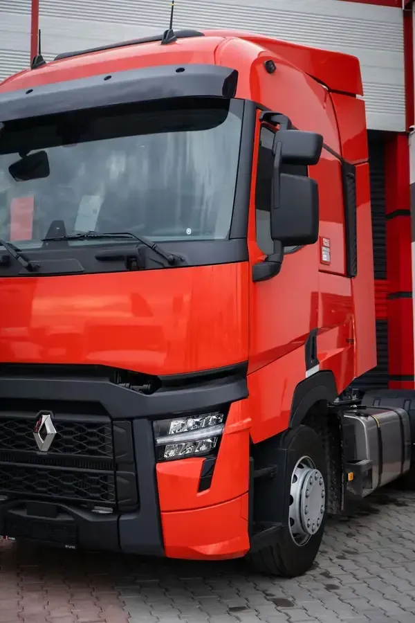 A bright red Renault semi-truck cab parked on a paved lot.
