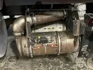 A vehicle exhaust aftertreatment system, including a diesel particulate filter, mounted under a truck chassis.