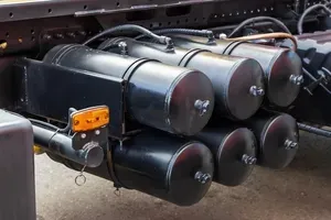A series of black cylindrical air tanks mounted on the side frame of a heavy-duty truck chassis.