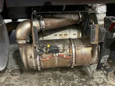 A vehicle exhaust aftertreatment system, including a diesel particulate filter, mounted under a truck chassis.