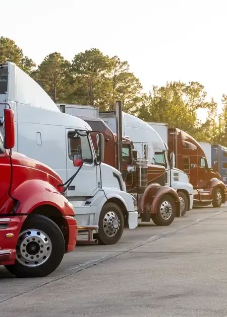 Front-facing view of a white Freightliner cab-over semi-truck parked inside a garage.