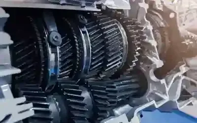 A cross-section view of a complex automotive transmission system featuring interconnected metal gears and shafts.