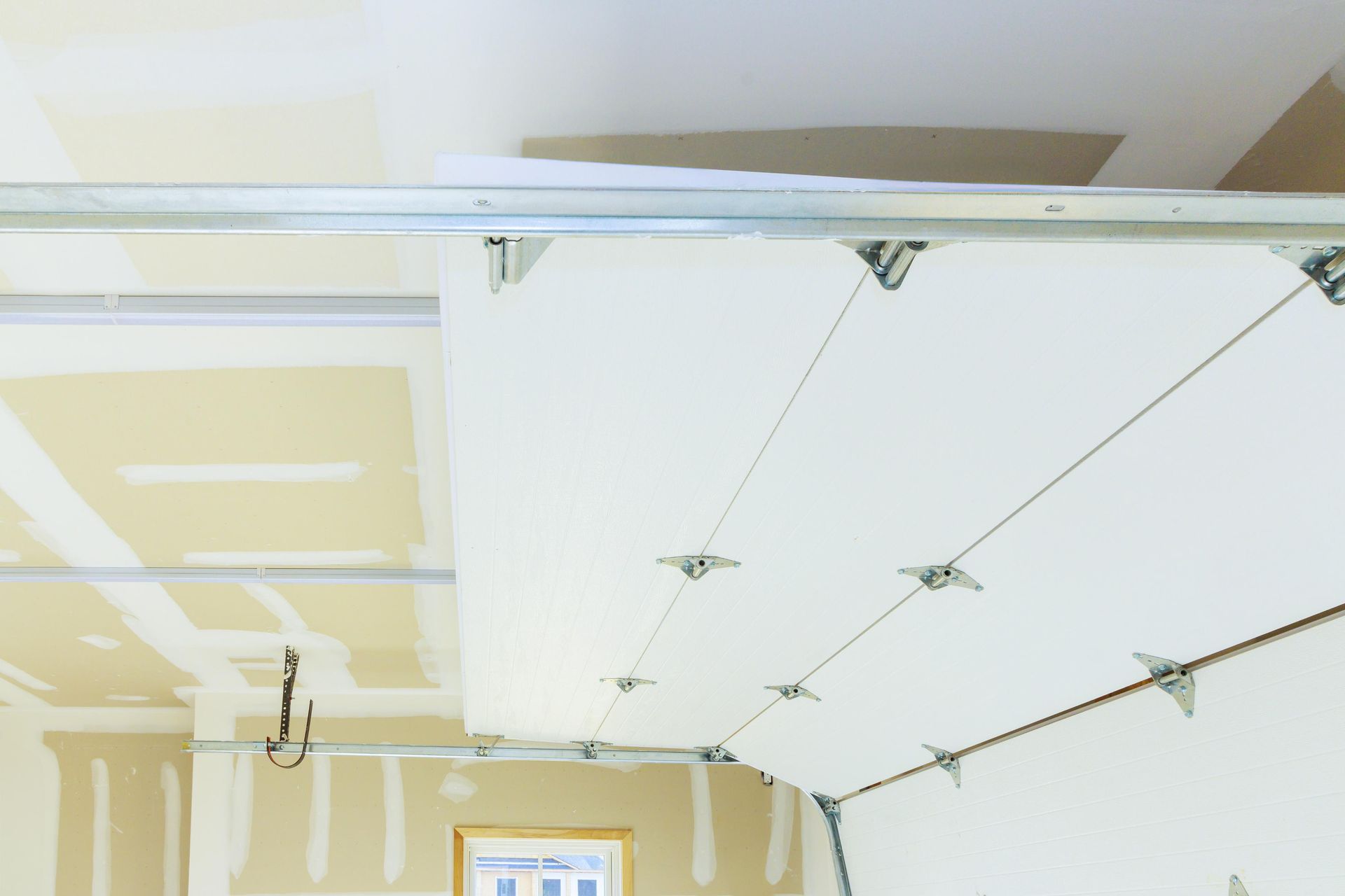 Garage ceiling with drywall and tracks for the garage door.
