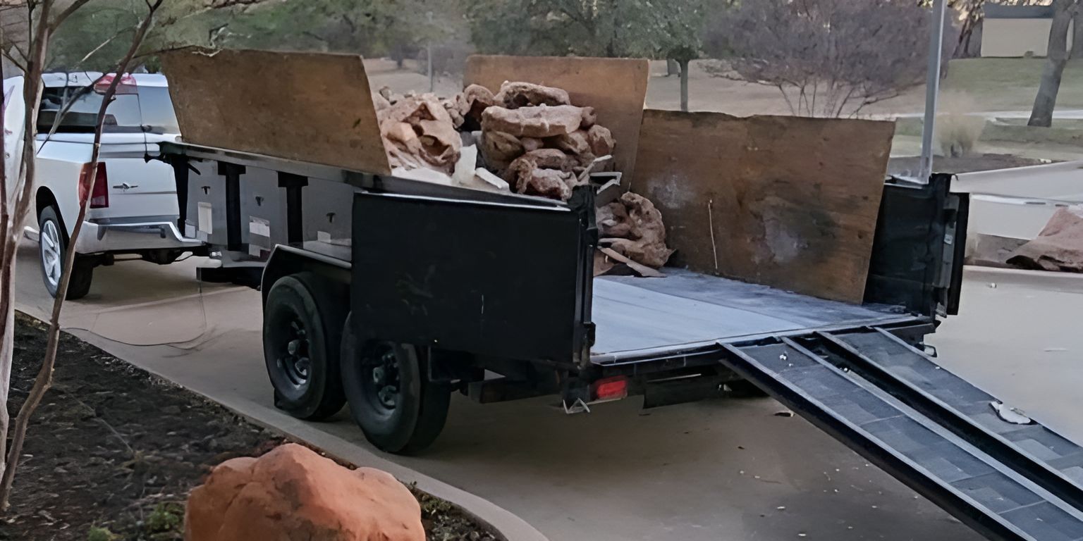 A trailer is parked in a driveway next to a truck.