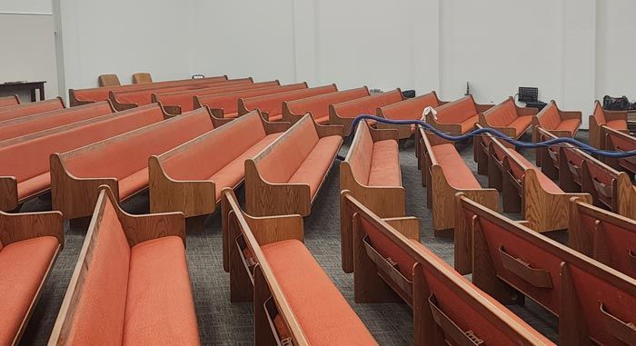 Rows of red benches in an empty church