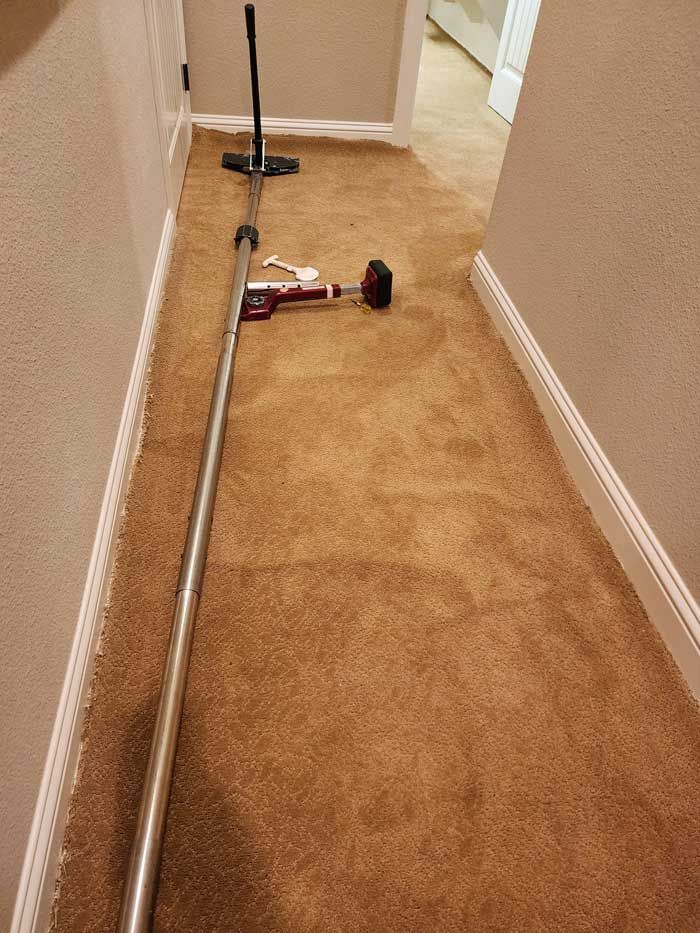 A vacuum cleaner is sitting on the floor in a hallway.