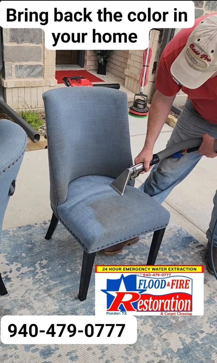 A man is cleaning a chair with a vacuum cleaner.