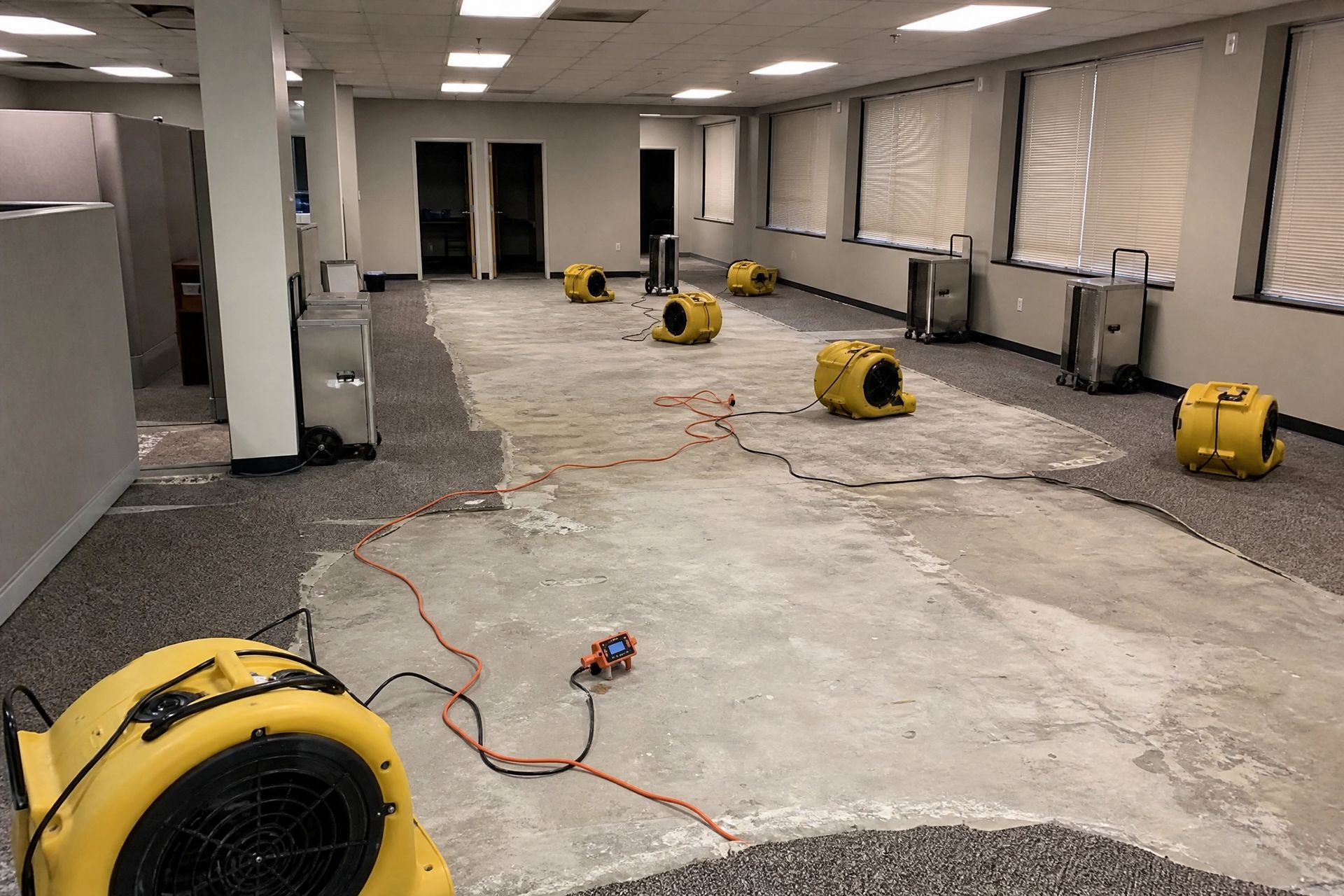 Commercial office space with industrial air movers and dehumidifiers during water damage mitigation.