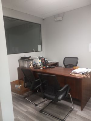 There is a desk and chairs in the office.