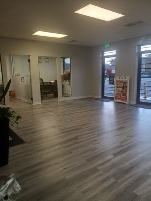 A large room with a wooden floor and a sign on the floor.