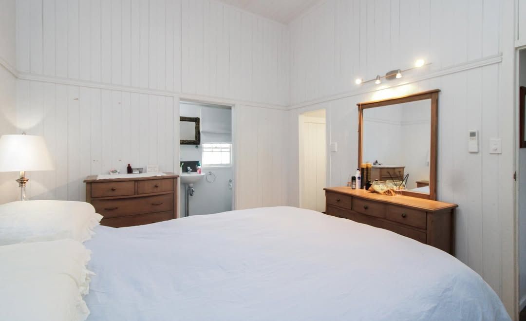 A Bedroom With A Bed, Dresser And Mirror — Outback Auctions and Real Estate in Cloncurry, QLD