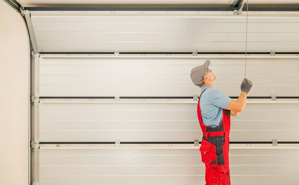 A man is installing a garage door in a garage.