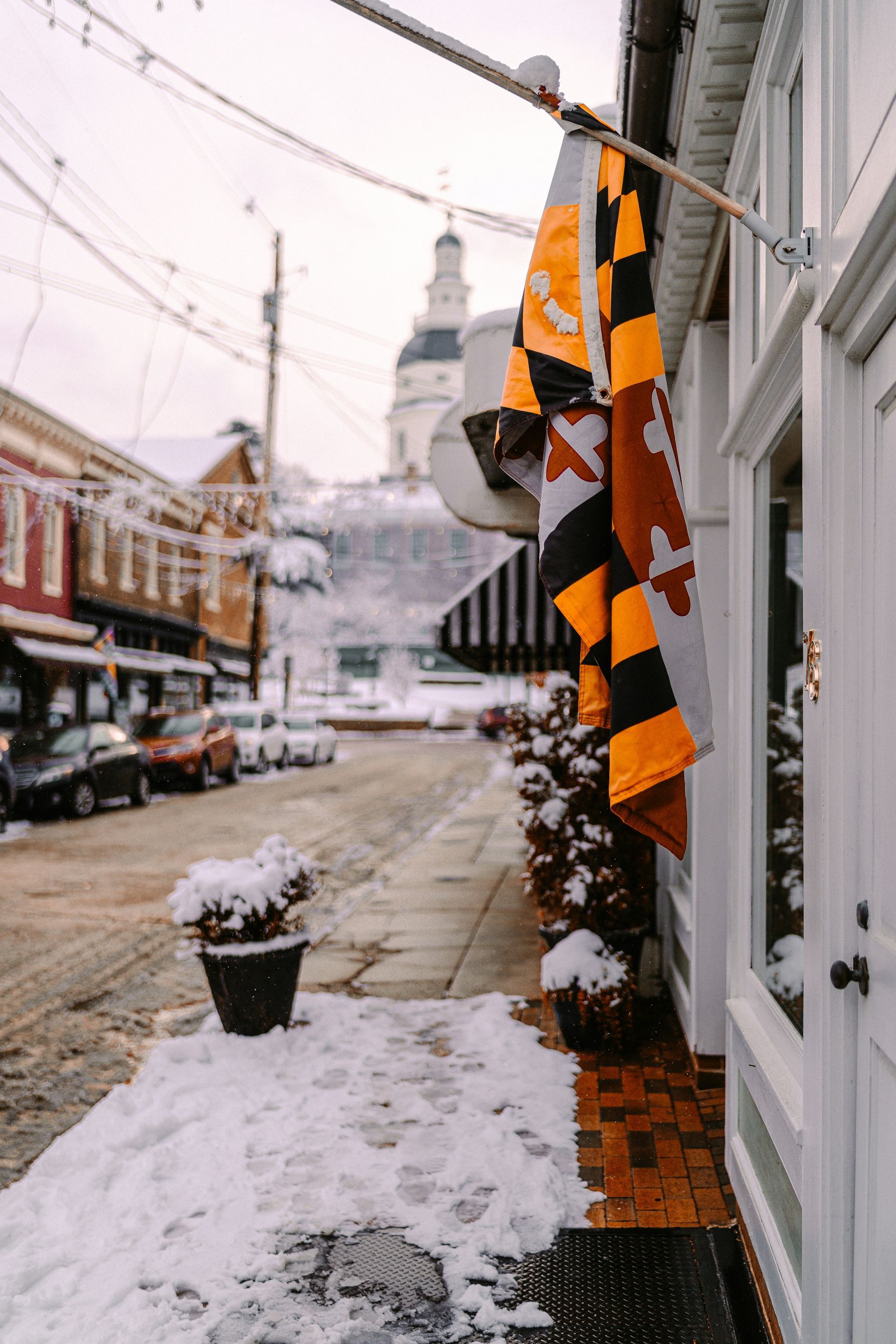 A yellow and black flag is hanging from the side of a building.