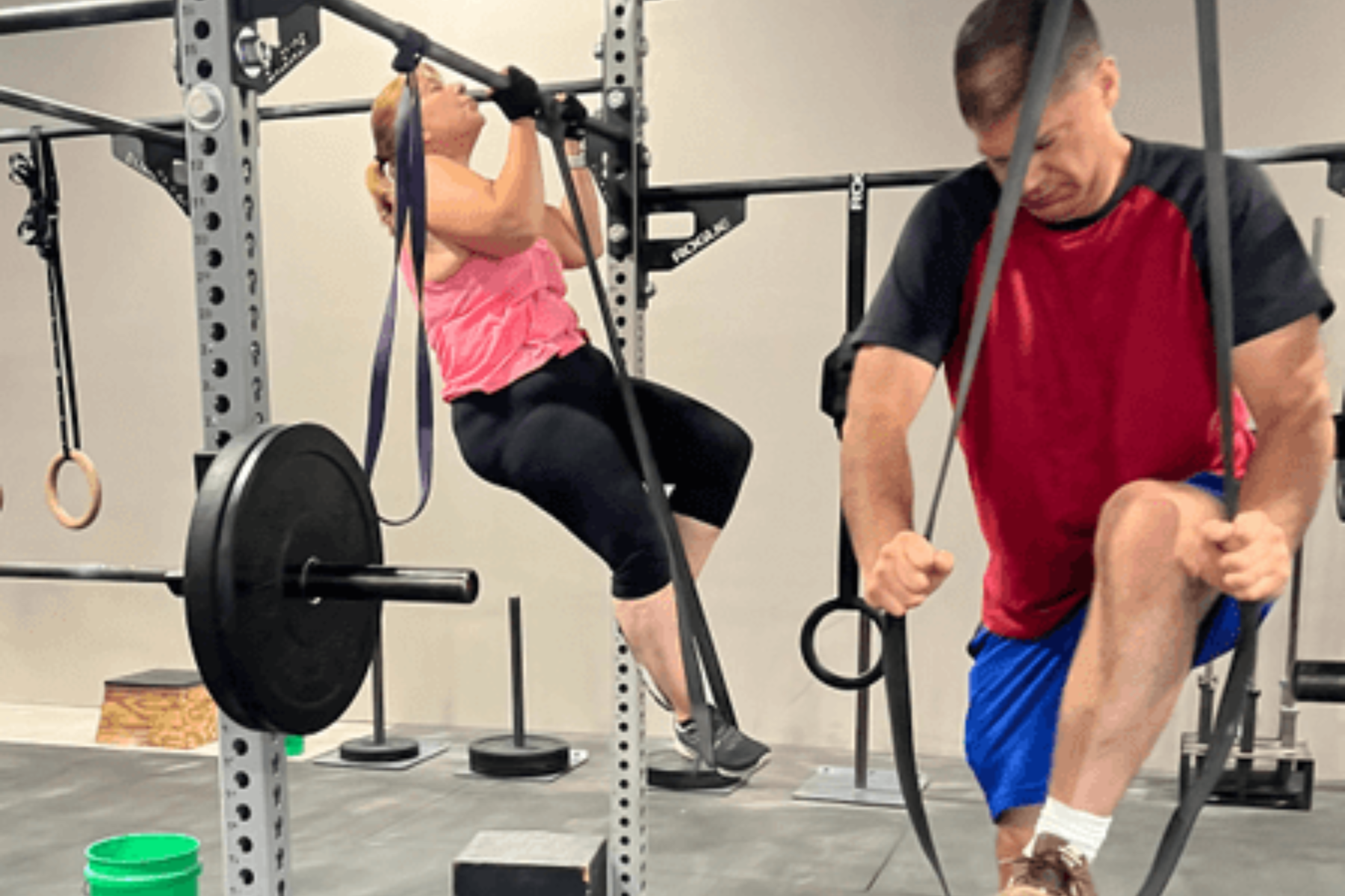 A man and a woman are doing exercises in a gym.