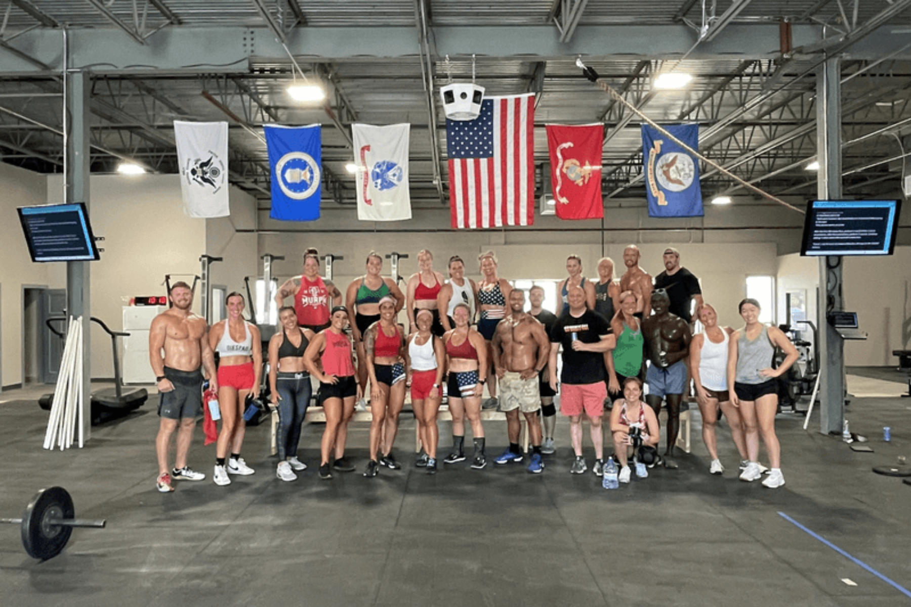A group of people are posing for a picture in a gym.