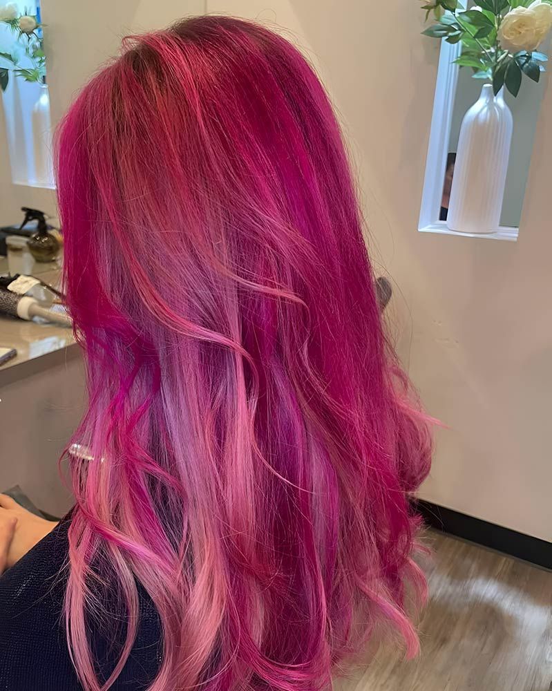 A Woman With Long Pink Hair is Sitting in a Salon — Artistry of Hair in Redlynch, QLD