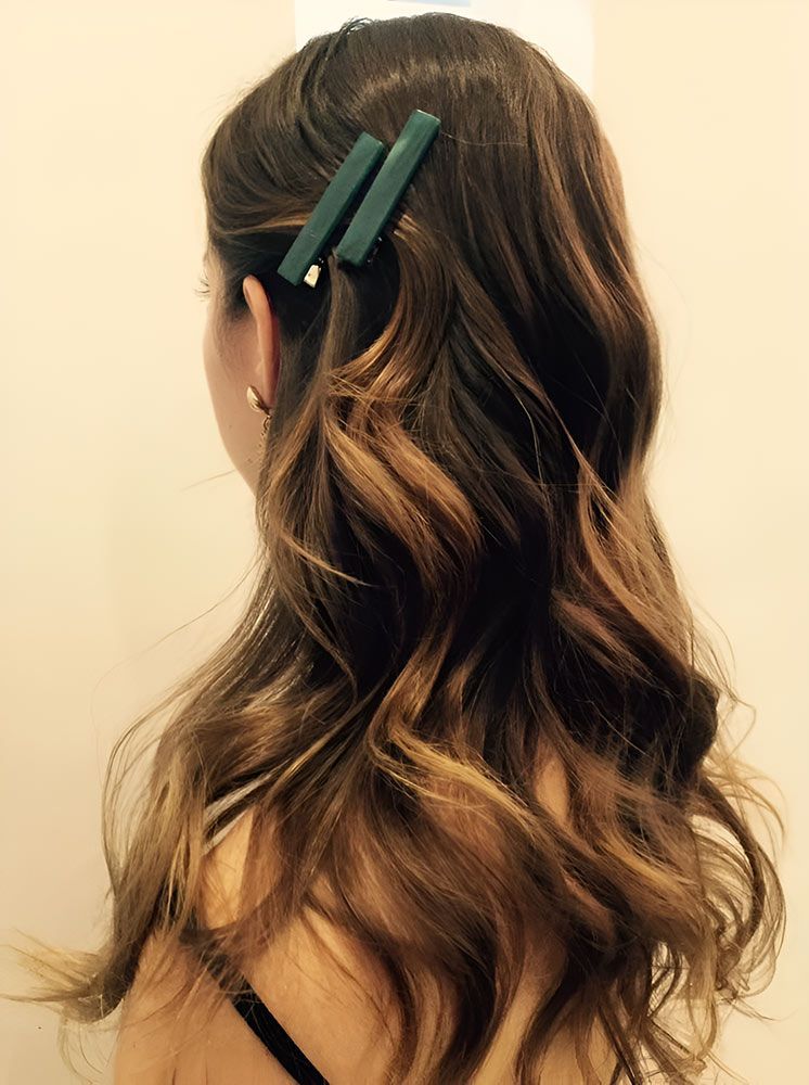 A Woman With Long Brown Hair is Wearing a Green Hair Clip — Artistry of Hair in Redlynch, QLD