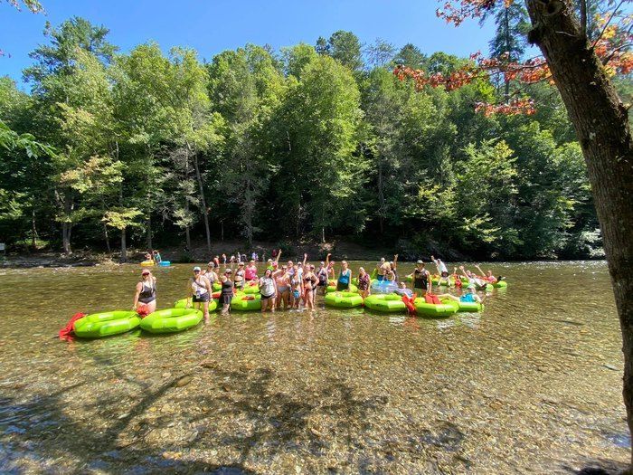 A group of people are floating on rafts in a river.