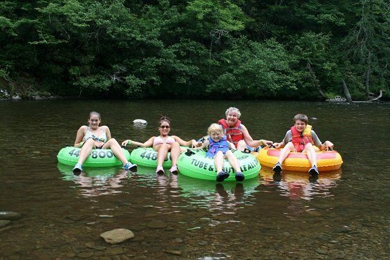 A group of people are floating down a river on tubes.