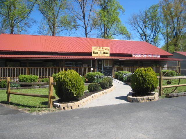 A building with a red roof and a sign that says ' a & j ' on it