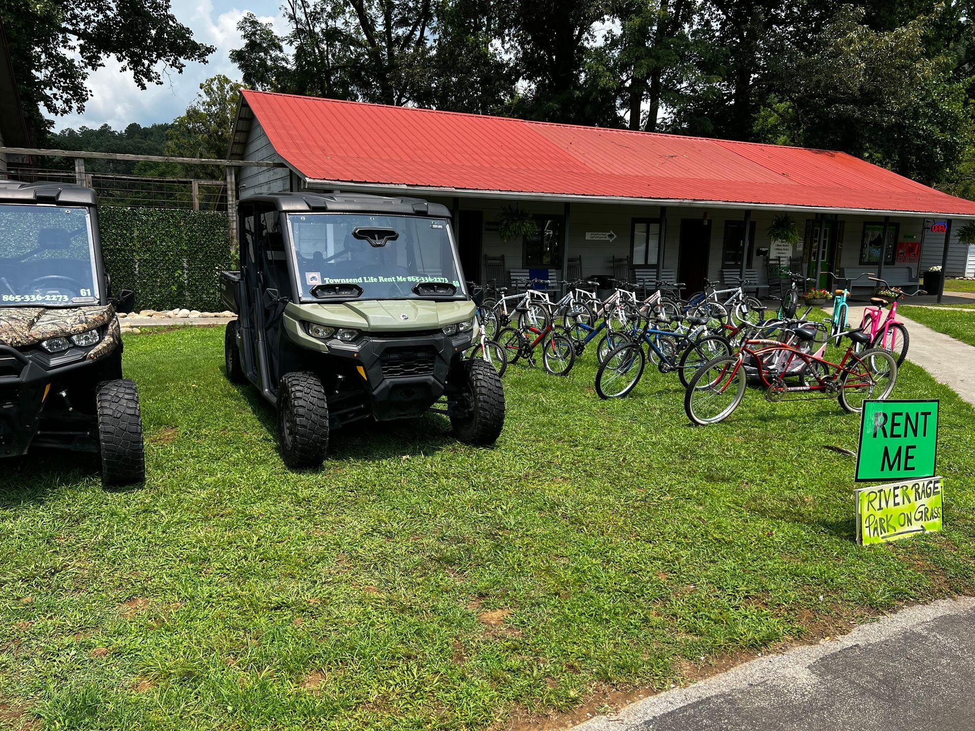 Two atvs are parked in front of a building with a red roof.