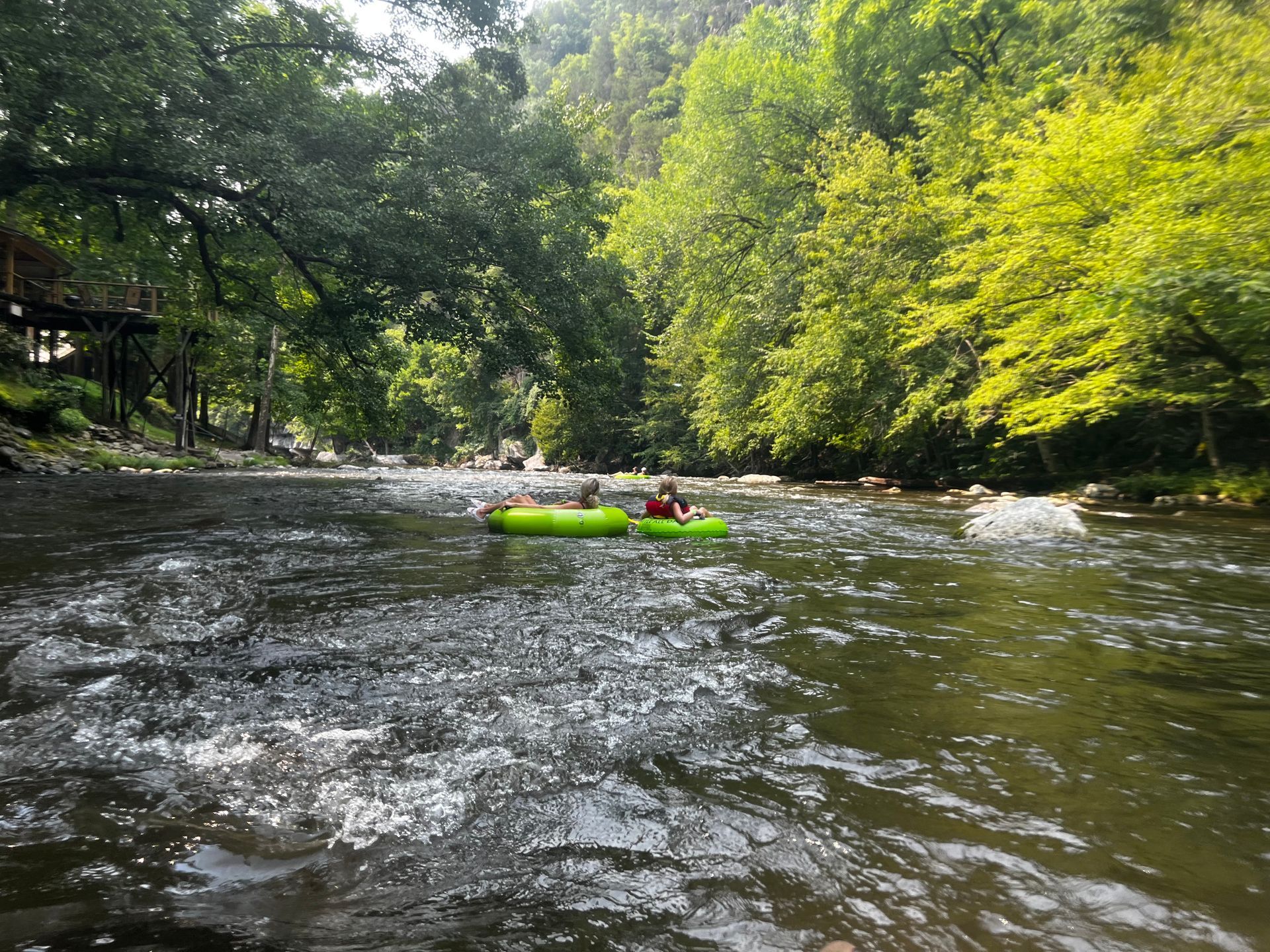A group of people are floating down a river in tubes.