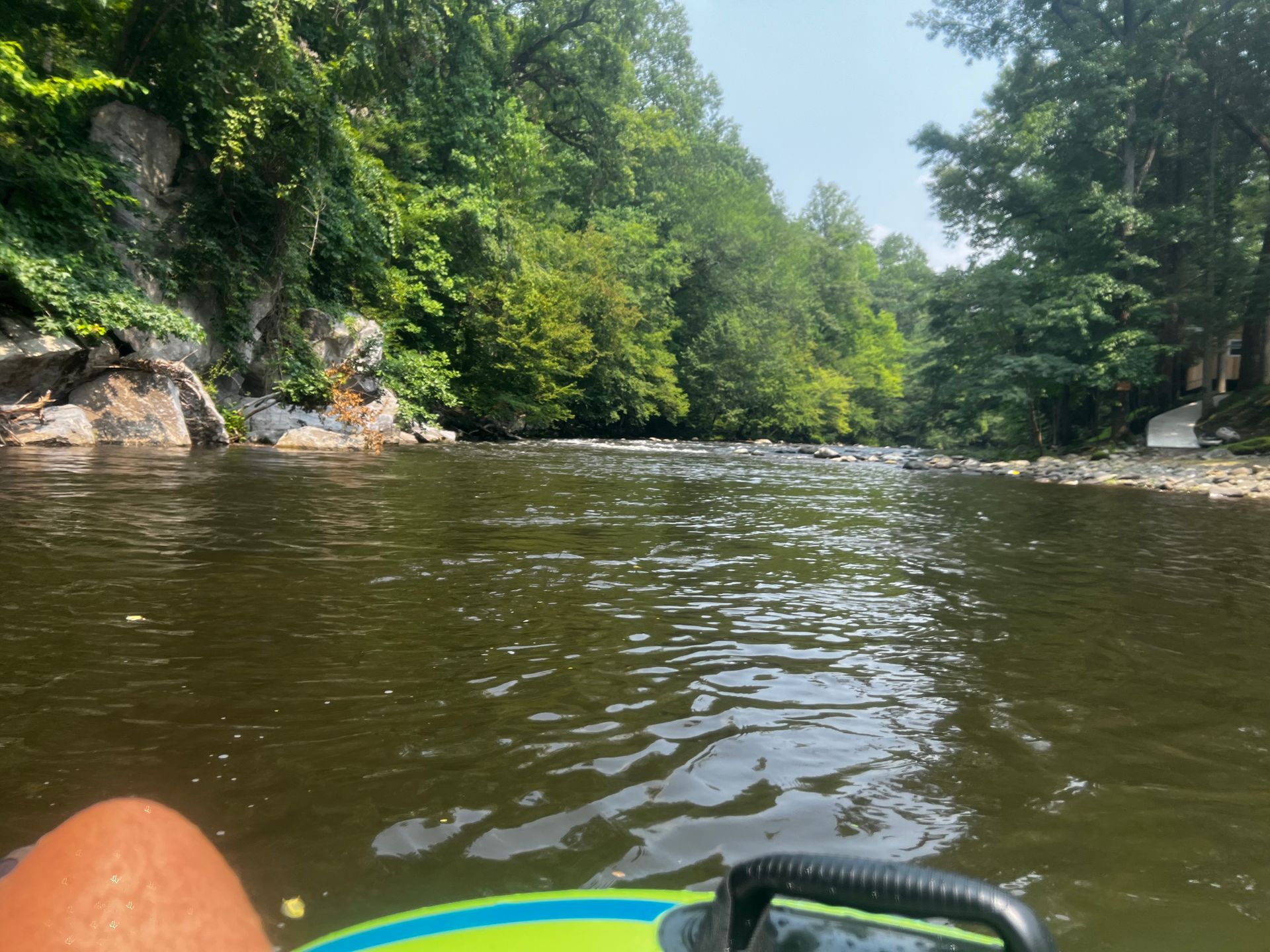 A person is floating on a tube in a river.
