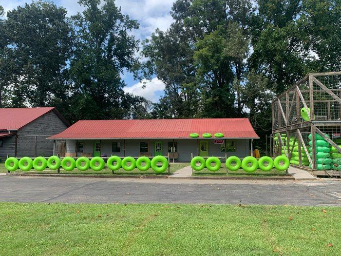 A building with a red roof and green tubes in front of it.