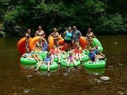 A group of people are sitting on rafts in a river.