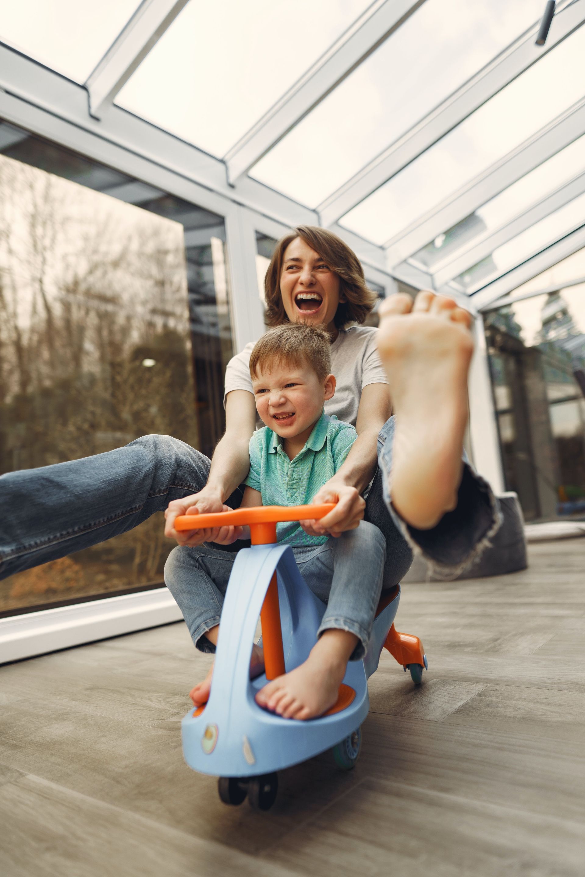 picture of mother and son riding a toddler's  wiggle car
