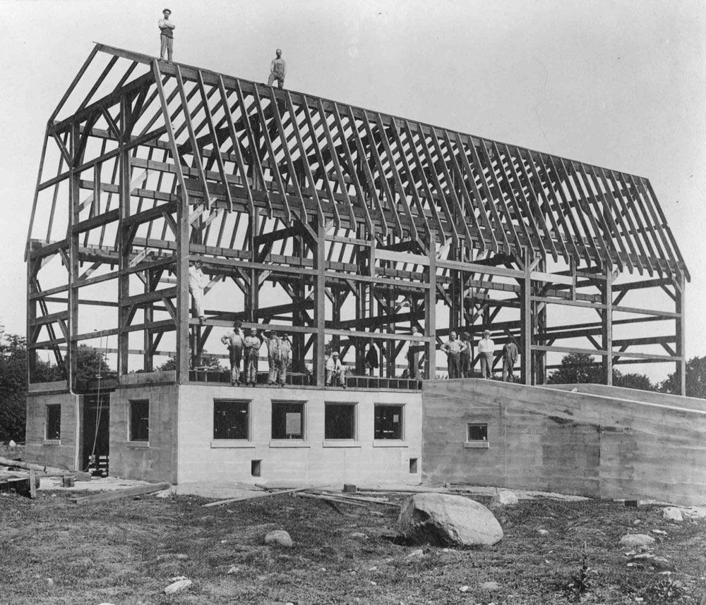 This photograph shows the construction of the cow barn at the Huronia Regional Centre farm. The barn’s concrete foundations have been poured and a wooden frame has been constructed. Workers can be seen sitting and standing on the foundations and the wooden beams of the frame. Under J.P. Downey’s tenure as Superintendent, the institution farm was expanded by 270 acres. Almost all work at the farm was carried out using the unpaid labour of residents. Image from the Regional Centre Records.)