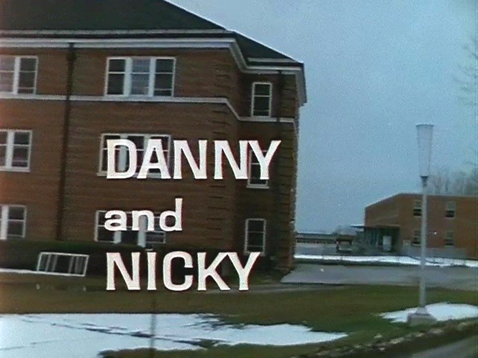 The title screen from the documentary Danny and Nicky, showing the film’s title superimposed over Cottage O on an overcast winter day. Image from the National Film Board of Canada documentary Danny and Nicky.