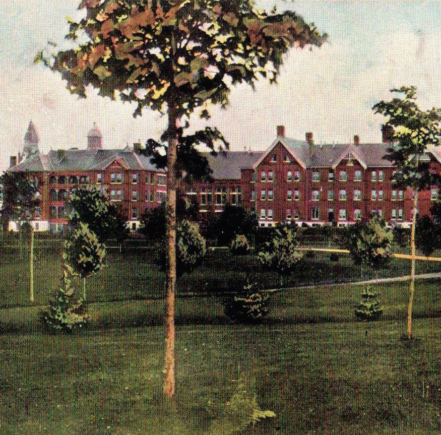 A postcard showing a view of the institution during Alexander Beaton’s tenure as Superintendent. This image shows the two men’s cottages, A and B, as viewed from what is now Memorial Avenue. Between these two three storey brick buildings we can see the church-like structure of the institution’s recreation hall.)