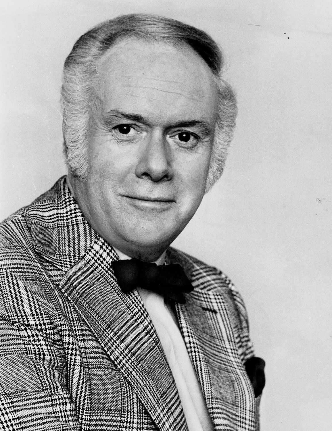 Canadian historian and journalist Pierre Berton. On New Years Eve, 1959, Berton toured the Huronia Regional Centre and penned an exposé describing the atrocious living conditions he found at the institution. Berton is an older white man with a receding hairline. He is wearing a plaid blazer and a black bowtie. Image from the Toronto Star Archives.