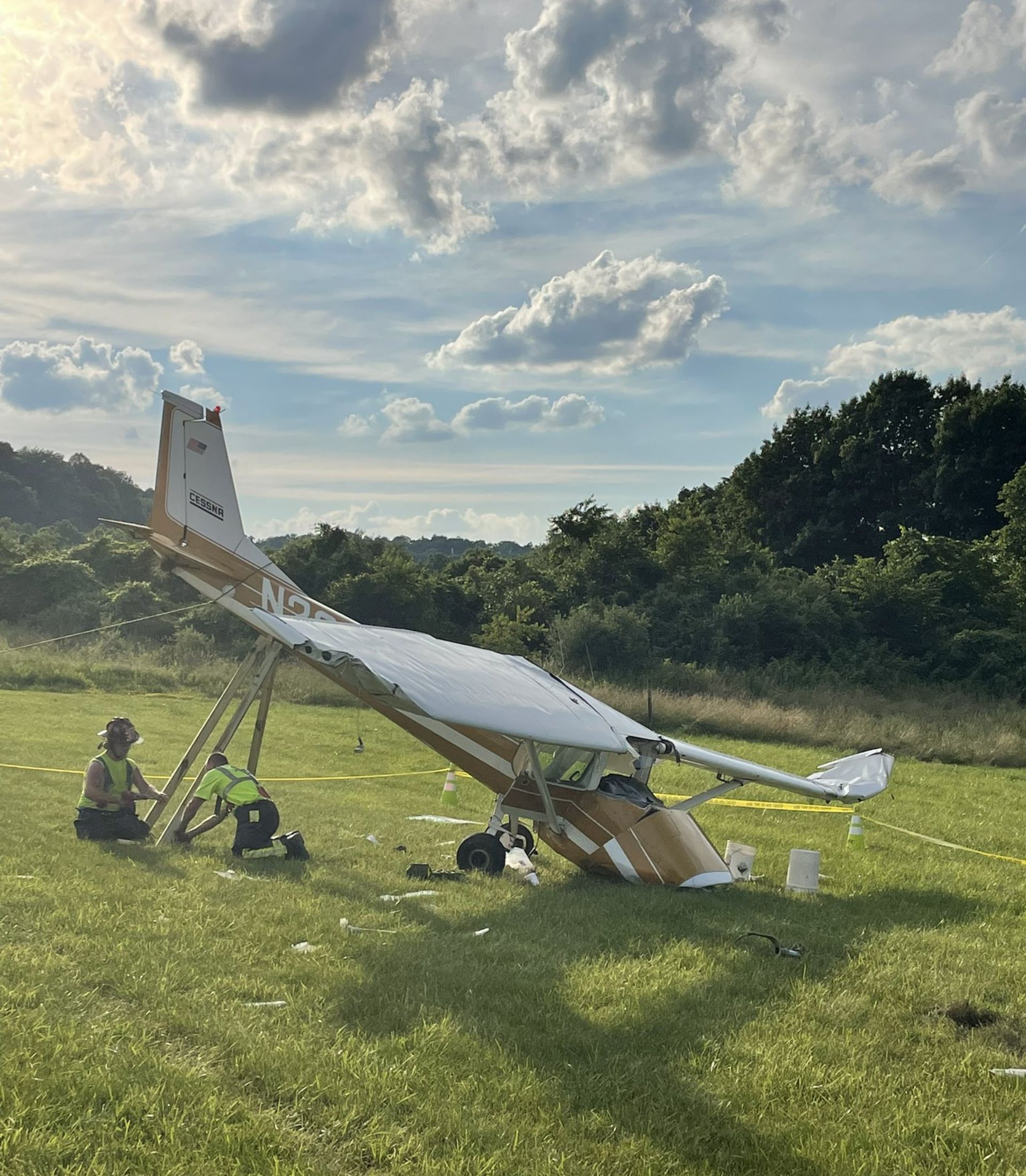 a plane with a broken wing sits in a grassy field