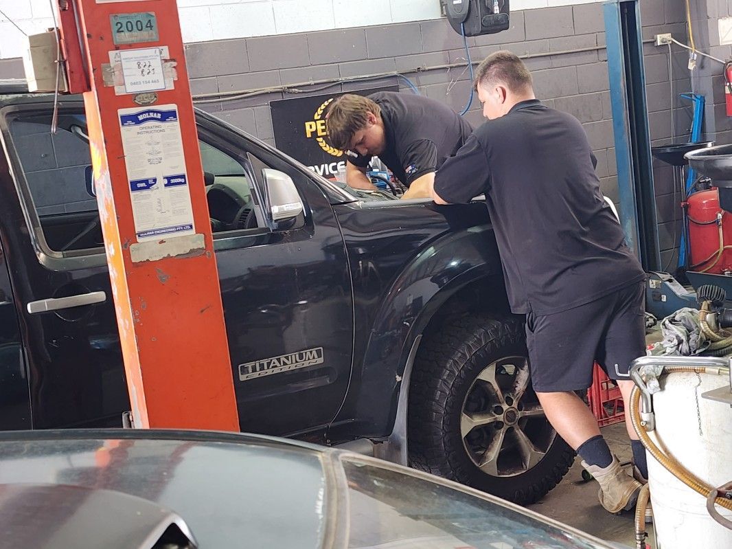 A Mechanic Inspecting The Roadworthy Of The Car