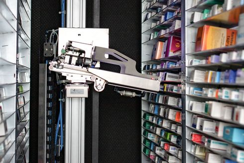 Ein Roboter arbeitet in einer Apotheke, die mit Medikamentenregalen gefüllt ist.