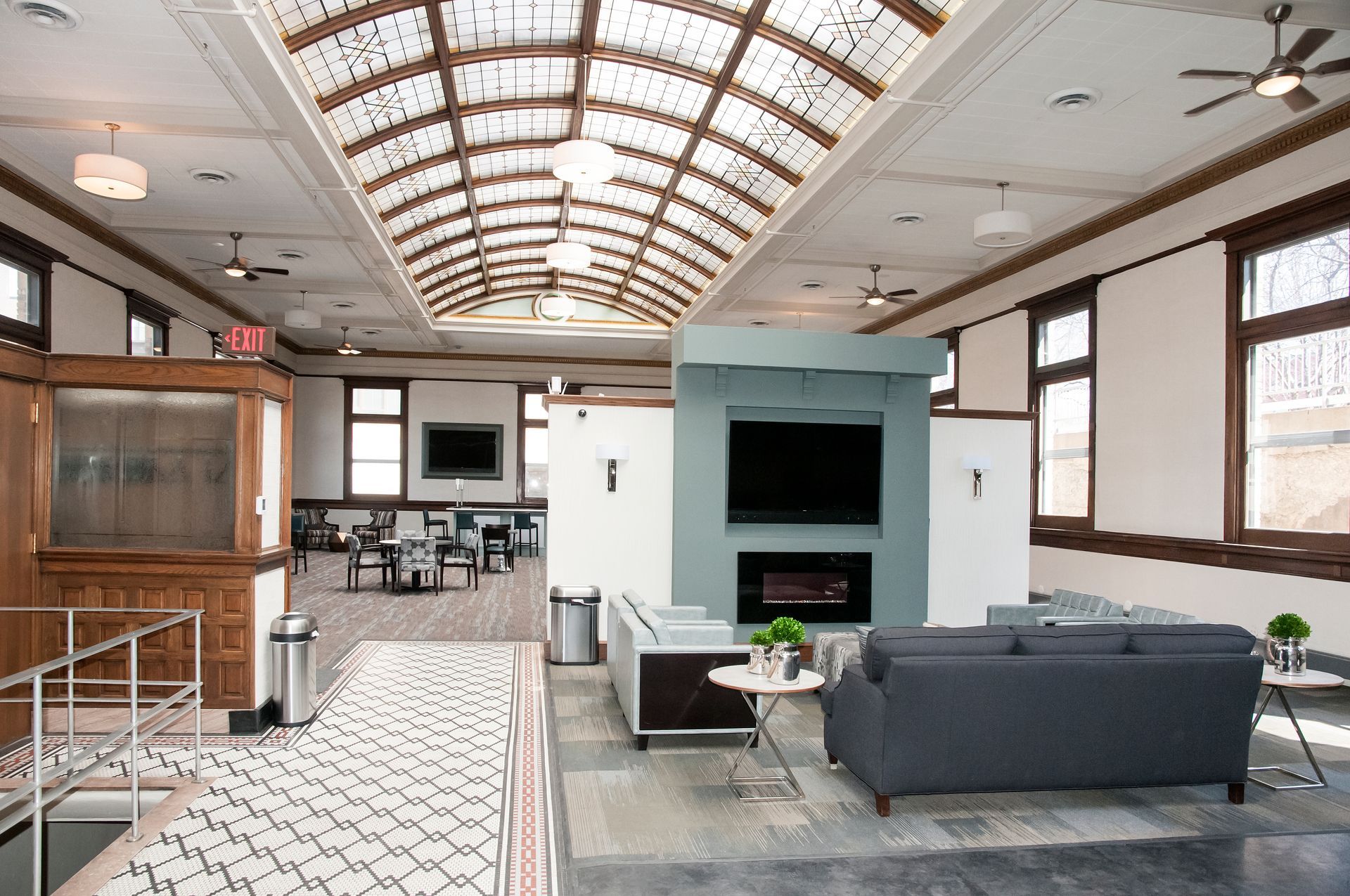 A modern lounge area with sofas, a fireplace, and a large skylight.