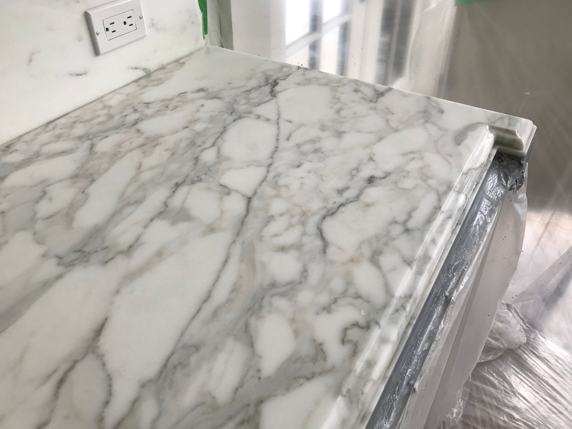 A close up of a white marble counter top in a kitchen.