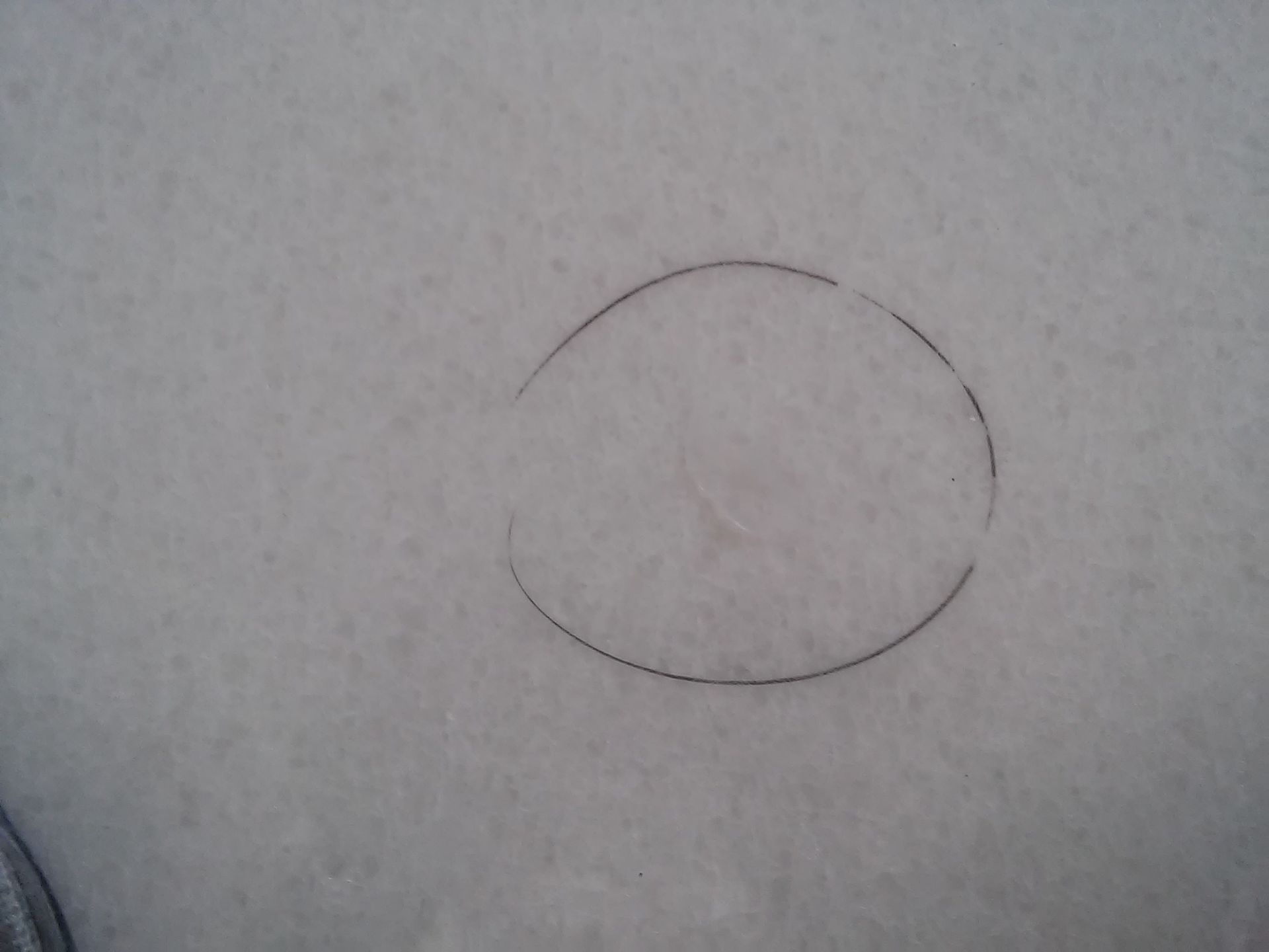 A circle is drawn in the snow on a white surface.