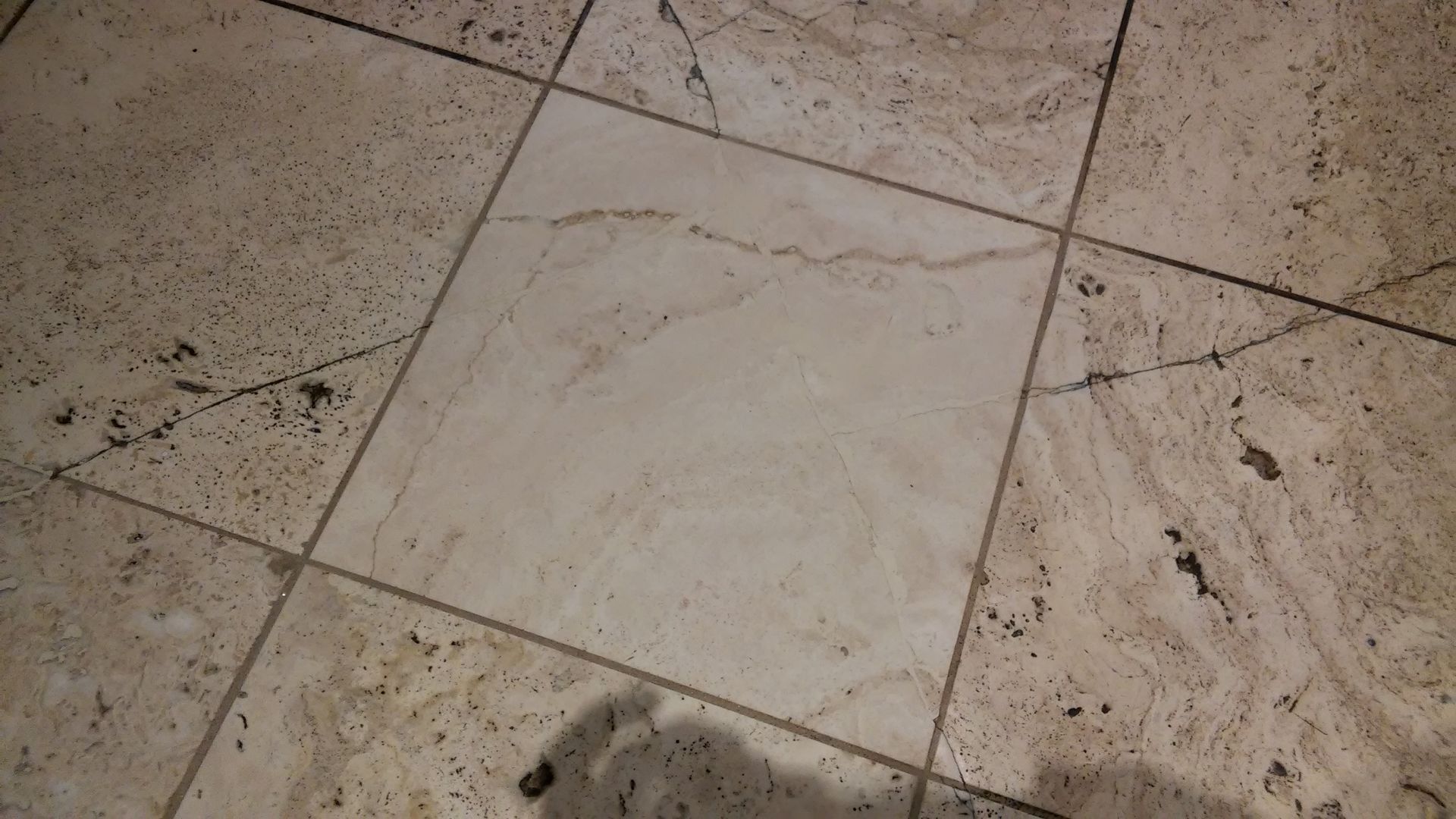 A close up of a tiled floor with a square in the middle.