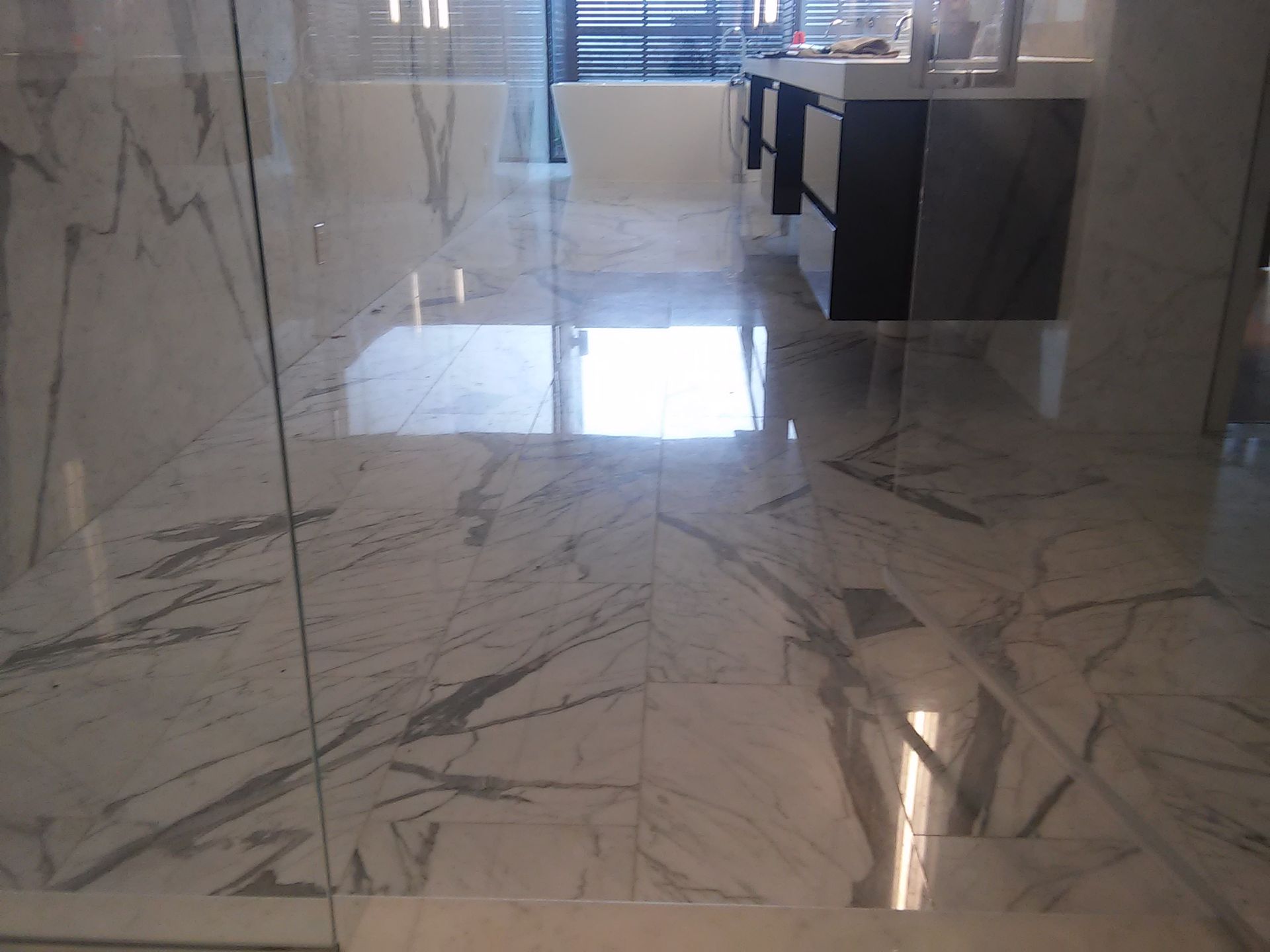 A bathroom with marble floors and a bathtub
